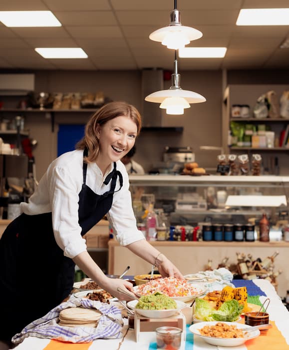 woman smiling in cafe with food around her